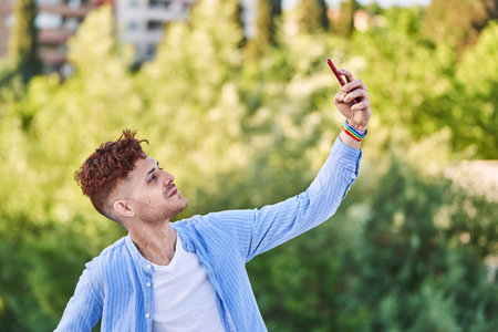 Young gay man with lgtb bracelet taking a selfie. Concept of LGBT, relationship and equal rights.の写真素材