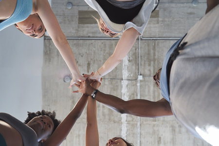 View from below of sporty people high five celebrating after training together. Sports concept.の写真素材