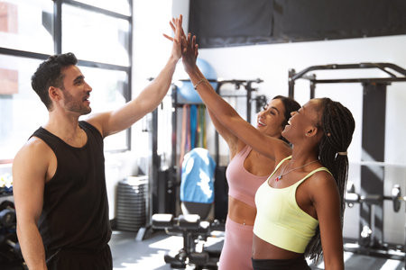 group of fitness friends high-fiving each other very smiling at the end of the workoutの写真素材