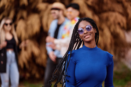 African American woman with sunglasses smiling while having fun at an outdoor party.