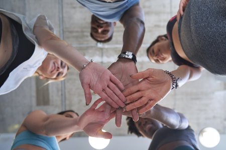 View from below of sporty people high five celebrating after training together. Sports concept.の写真素材