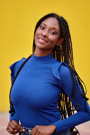 Portrait of an African American woman looking at camera and smiling while posing.の写真素材