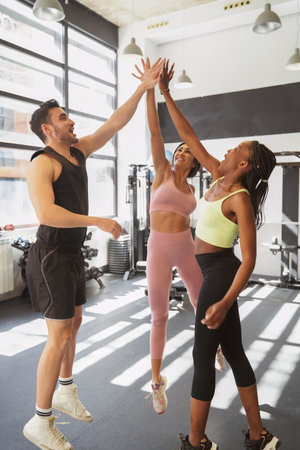 group of fitness friends high-fiving each other very smiling at the end of the workoutの写真素材