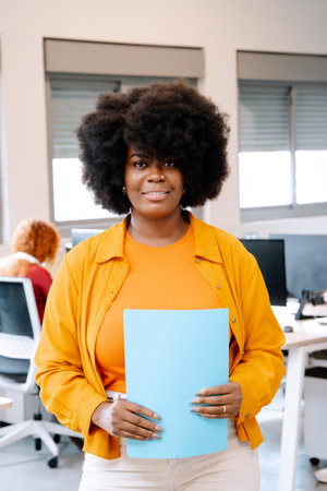 African American businesswoman looking at camera while posing standing in the office. Business concept.の写真素材