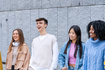Youthful group of friends enjoying a fun moment together, with genuine smiles and laughter in front...