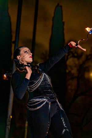 Fire dancer performing with flaming props at a night show, creating a captivating spectacleの写真素材