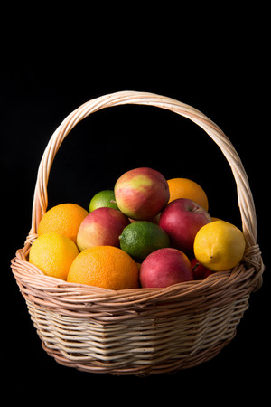 Fresh fruits in a basket on black backgroundの写真素材