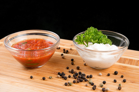 Sauces in bowls, pepper on a wooden boardの写真素材