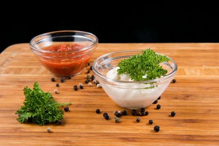 Sauces and pepper on a wooden boardの写真素材