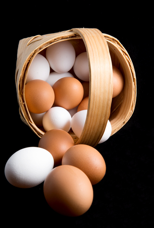 Eggs in a birch bark basket on black backgroundの写真素材