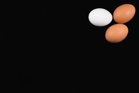 Three eggs on black background, top viewの写真素材