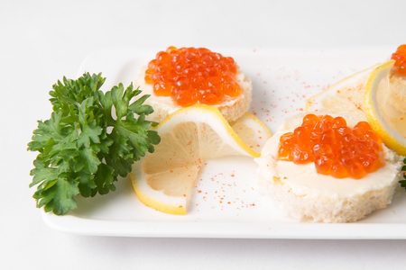 Sandwiches with red caviar on white plateの写真素材