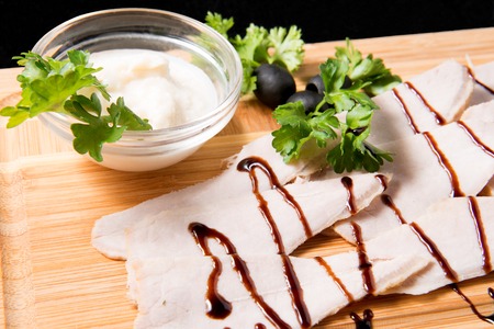 Slices of boiled pork and sauce on a wooden boardの写真素材