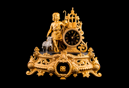 Vintage bronze table clock on black backgroundの写真素材