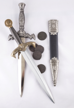Military daggers and coins on white background, isolatedの写真素材