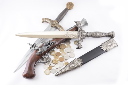 Old military daggers, gun and coins on white backgroundの写真素材