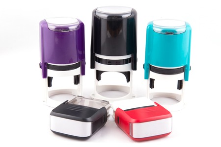 Automatic hand-stamps different colours on white backgroundの写真素材