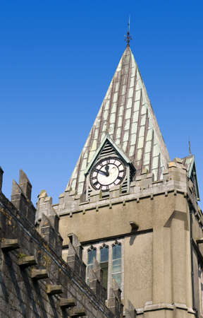 Detail of an old church building showing the clock tower and clock, against a clear blue sky.  の写真素材
