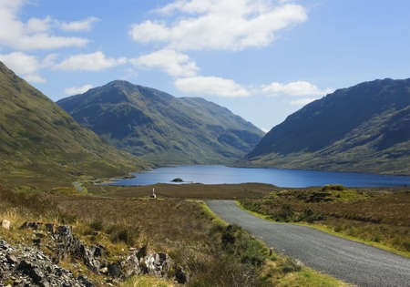 Mountain road in the west of Ireland, leading past a wayside monument erected in memory of the victims of the 1845-1846 Irish Potato Famine, who wandered through this countryside in search of food. の写真素材