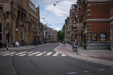 People walking the streets of downtown Amsterdam on a cloudy day, Holland, The Netherlands