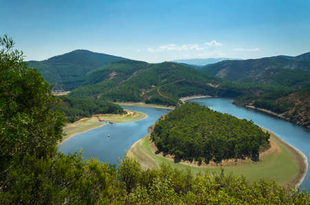 Meander of Melero surrounded by mountains on a day with blue sky, Riomalo de Abajo, Las Hurdes,...