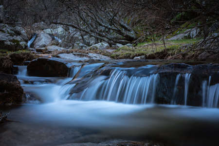 River water flows among the rocks and forms small waterfalls, RascafrÃ­a, Madrid, Spain