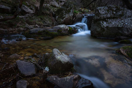 River water flows among the rocks and forms small waterfalls, RascafrÃ­a, Madrid, Spain