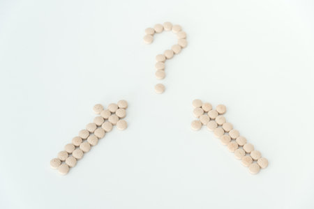 Light brown pills on white background close up top view with copy spaceの写真素材