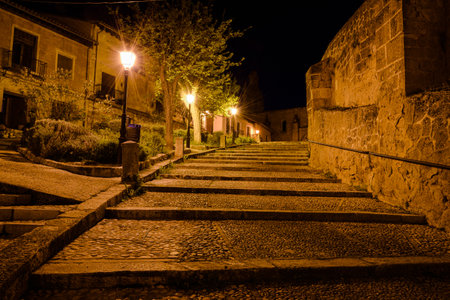 Cobbled staircase in the streets of Cifuentes with the church of Santo Domingo in the background at night, Guadalajara, Spainの写真素材