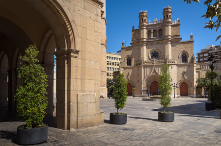 Main square of Castellon de la Plana with the Co-Cathedral of Santa Maria in the background and the arcades of the city council building on a sunny day with a blue sky, Spainの写真素材