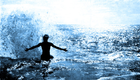 Ocean Wave Splashing on a Man sitting on a cliffの写真素材