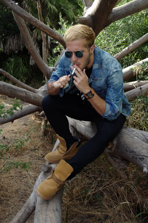 Male portrait by a dead, fallen tree trunk 22の写真素材