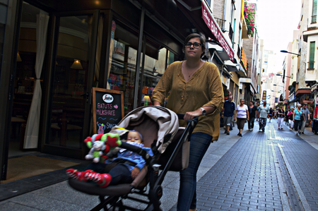 Lloret de Mar (Girona) Spain 15-10-2014 - Urban life: Young lady with a pramのeditorial素材