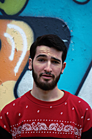 Young man in front of some graffiti の写真素材