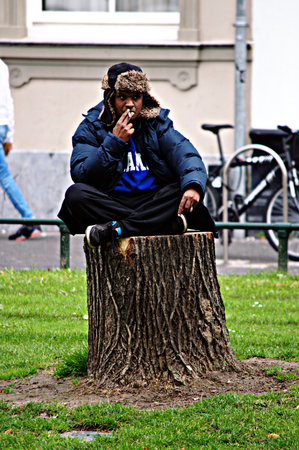 Netherlands, Rotterdam, 8th, October, 2015 - Man sitting on a tree trunkのeditorial素材