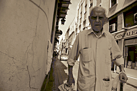 Seville - Spain - 24 May 2016 - Urban life. Senior walking in the street. Variation in sepia.のeditorial素材