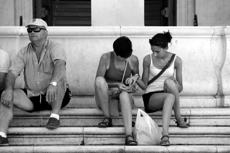 Seville - Spain - 5 August 2016- Urban life: People sitting on some stepsのeditorial素材