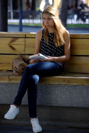 Seville, Spain, 27th September, 2016 - Urban life  - Young lady reading outdoorsのeditorial素材