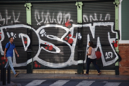 Sevilla, Spain, 13/9/2017 - Urban life - People walking in front of a wall with graffitiのeditorial素材