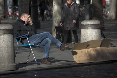 Seville, Spain, 24th January 2018 - Urban life - Embarrased beggarman asking for almsのeditorial素材