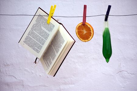 Still life with codom, book and orangeの写真素材