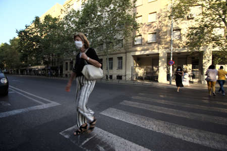 Seville, 23 July 2020 A lady is walking in the street. She is wearing a mask
