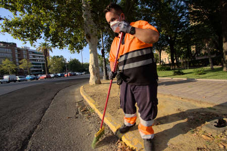 Seville, 23 July 2020 A man (a worker) sweeping the streetsのeditorial素材