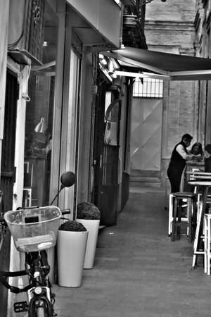 This is a very narrow street at the very center of Seville. There is small cafe in it.の写真素材