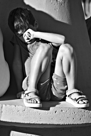 Every year there is a pilgrimage in Carmona in honor to the patron saint. This is a lonely and sleppy child in a seat of a parkの写真素材