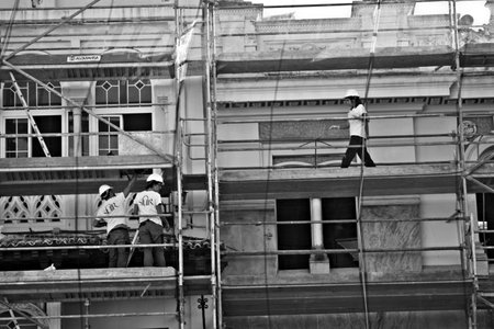 Workers on a scaffold in Seville. They are doing repairs in a house