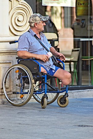 This photo is part of an assignment in a photo walk. A cripple isn siiting on a wheelchair and beggingのeditorial素材