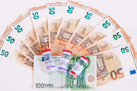 Three different vaccines to fight the coronavirus pandemic. The huge amount of money the European Union is spending. Euro banknotes, business with vaccines. Concept of treatment and cost.の写真素材