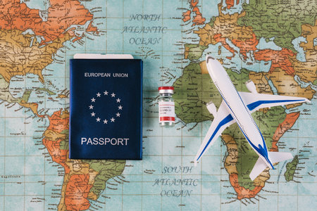 Safe travel during the pandemic, security checks at airports and borders. EU passport with airline ticket inside, Covid-19 vaccine and model plane on a world map background. Health Passport concept.の写真素材