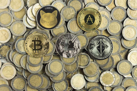Types of cryptocurrencies represented symbolically as coins over many two-euro coins. The most popular in global business economics and financial markets. Worldwide digital money concept.の写真素材